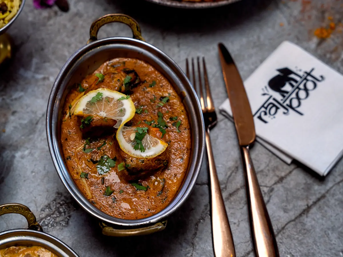 Karahi mijoté aux tomates et poivrons, servi dans un plat de cuivre