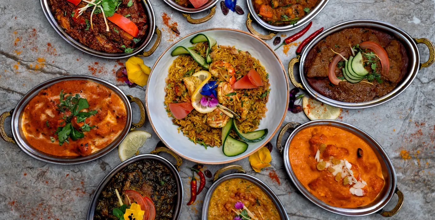 Table dressée au restaurant Rajpoot, plusieurs plats et naans partagés